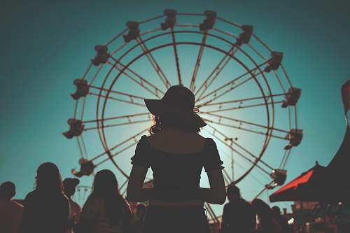 ferris wheel woman standing in front of ferris wheels surrounded with people amusement park